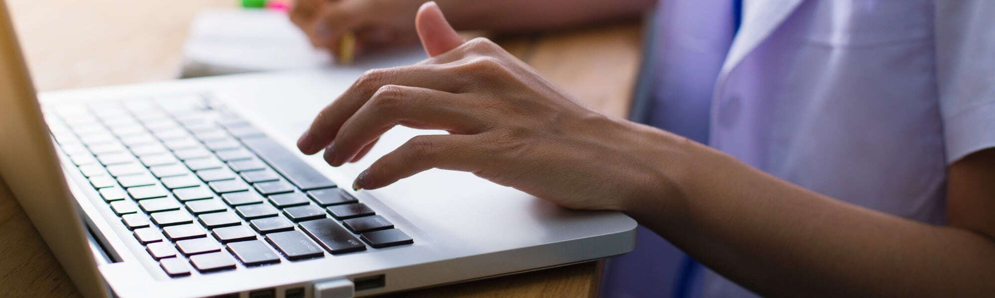 nurse typing on laptop keyboad